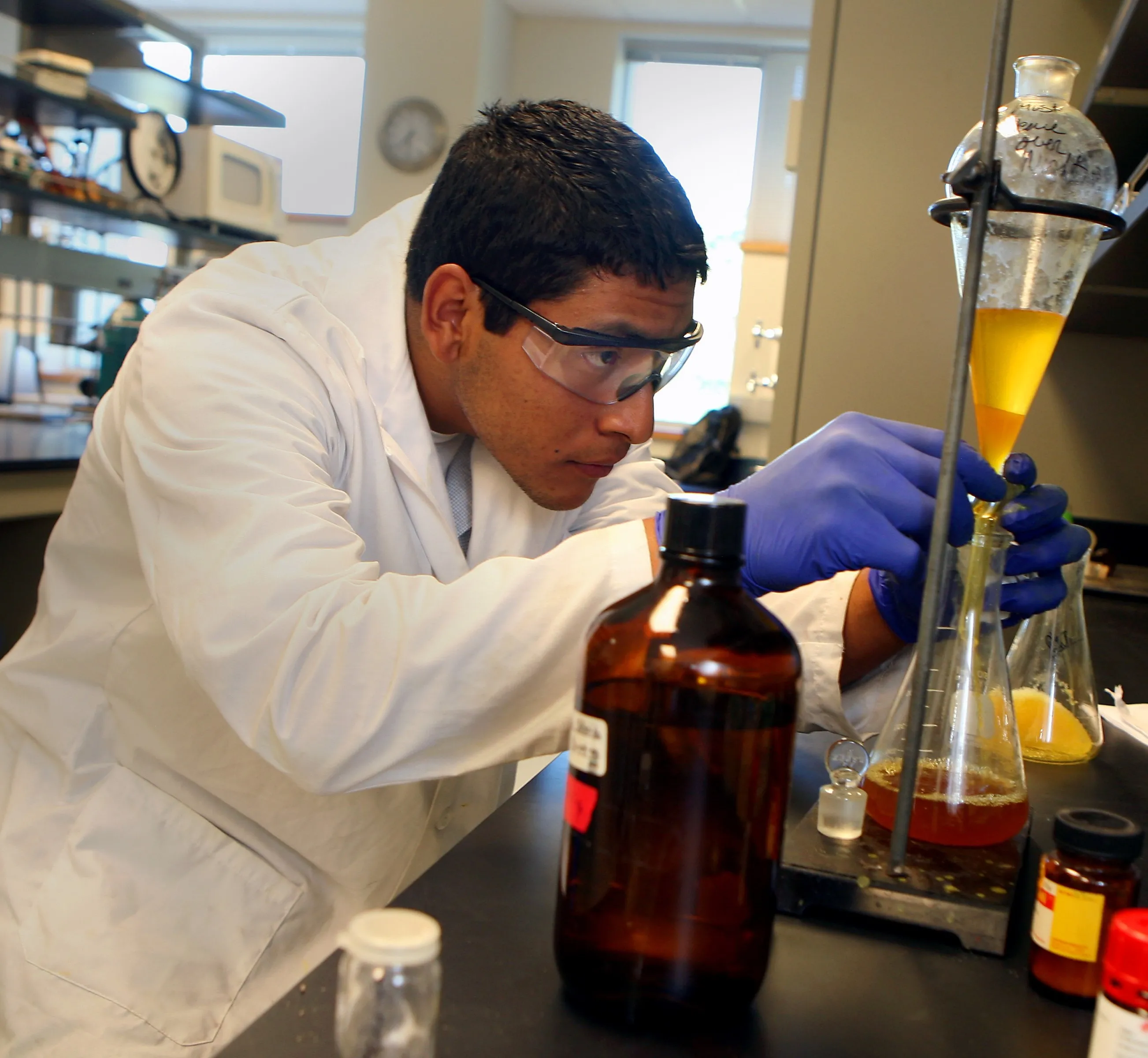 student in PPE distilling liquids